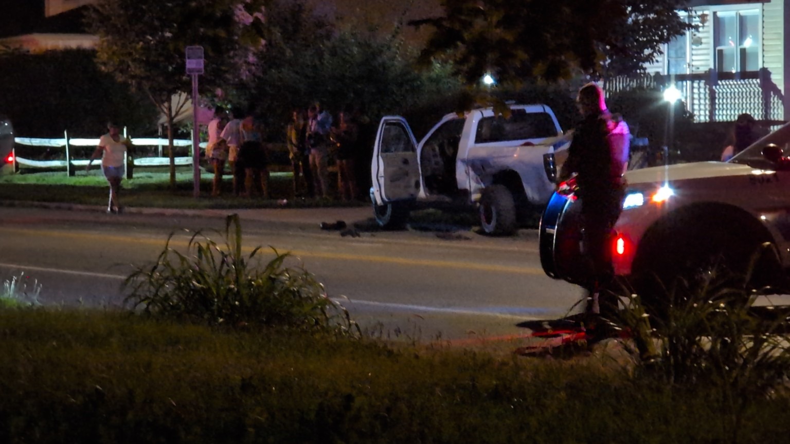 A vehicle and responders on a residential street at night.