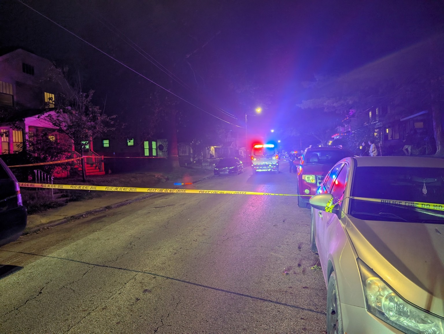 Another view of the taped-off street and response vehicles.