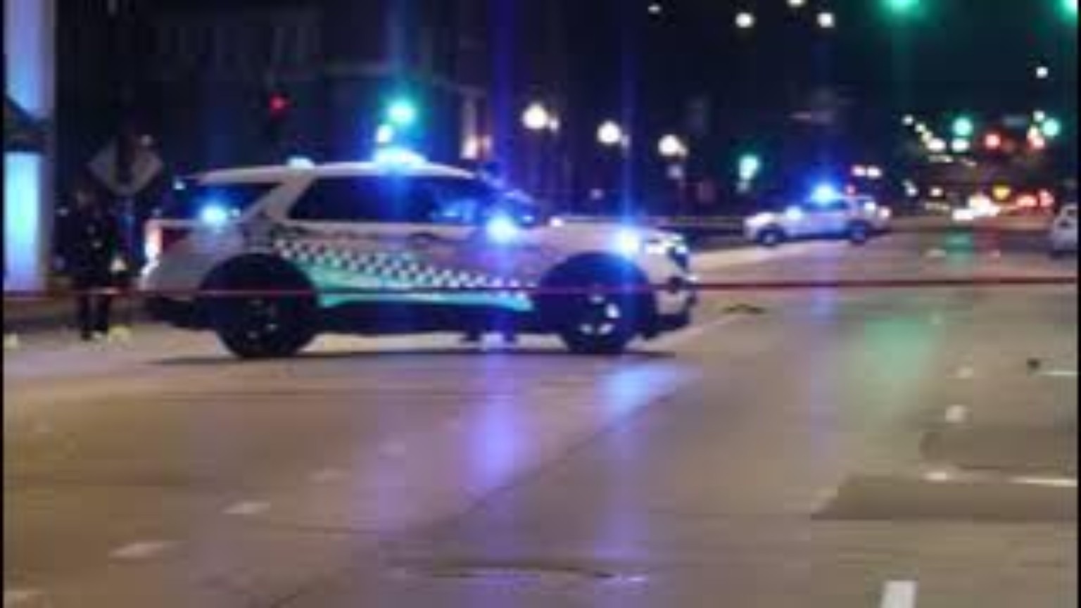 A marked police vehicle on a city street at night.